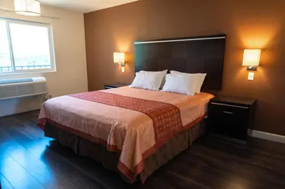 a hotel room with a large bed and a window at Maywood Inn in Maywood
