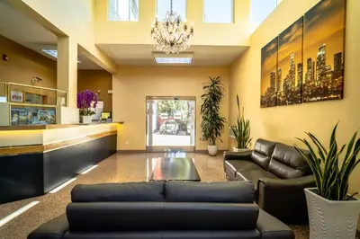 a living room with black leather furniture and a chandelier at Maywood Inn in Maywood