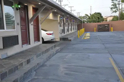 a white car parked outside of a building at Sun Light Motel in Downey