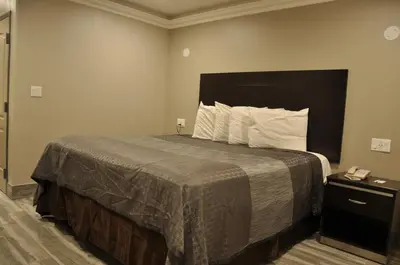 a hotel room with a bed and a phone at Sun Light Motel in Downey