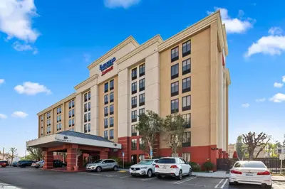 a hotel with cars parked in a parking lot at Fairfield Inn & Suites Anaheim North Buena Park in Buena Park