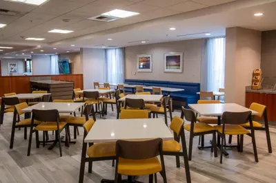 a dining room with white tables and yellow chairs at Fairfield Inn & Suites Anaheim North Buena Park in Buena Park