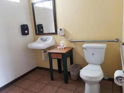 a bathroom with a toilet and a sink and a mirror at Casa Bella Inn Downtown LA in Los Angeles