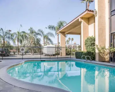 a swimming pool in front of a building at California Inn and Suites Bakersfield in Bakersfield