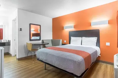 a hotel room with a bed and a table at Motel 6 Bakersfield in Bakersfield