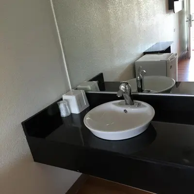 a bathroom with a black counter with a sink at Motel 6 Bakersfield in Bakersfield
