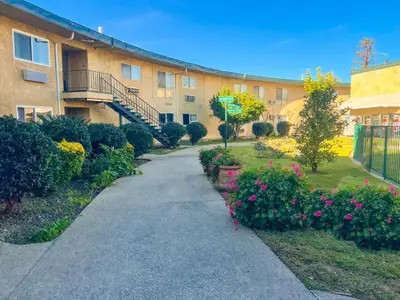 a walkway in front of a building with flowers at Hometown Inn North Hills in North Hills