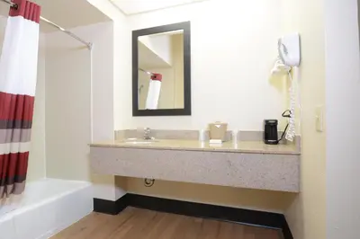 a bathroom with a sink and a bath tub at Red Roof Inn San Dimas - Fairplex in San Dimas