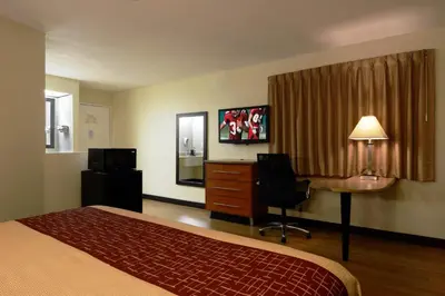 a hotel room with a bed and a desk and a chair at Red Roof Inn San Dimas - Fairplex in San Dimas