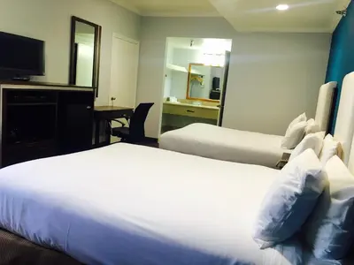 a hotel room with two beds and a mirror at Hotel Pacific, Manhattan Beach in Manhattan Beach