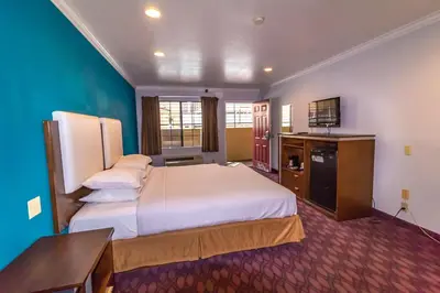 a hotel room with two beds and a television at Hotel Pacific, Manhattan Beach in Manhattan Beach