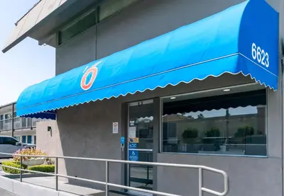 a store front with a blue awning on a building at Motel 6 Pico Rivera - Los Angeles, CA in Pico Rivera