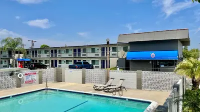 a pool in front of a hotel with a building at Motel 6 Pico Rivera - Los Angeles, CA in Pico Rivera