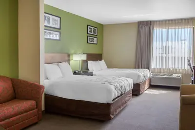 a hotel room with two beds and a couch at Sleep Inn & Suites Bakersfield North in Bakersfield