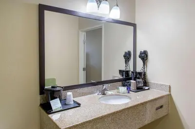 a bathroom with a sink and a large mirror at Sleep Inn & Suites Bakersfield North in Bakersfield