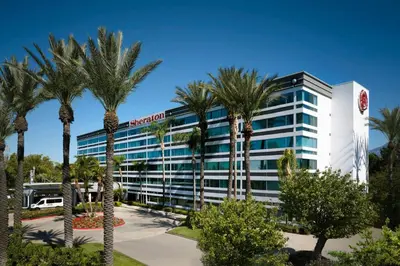 a hotel with palm trees in front of it at Sheraton Ontario Airport Hotel in Ontario