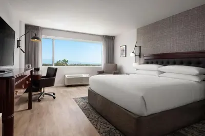 a hotel room with a large bed and a desk at Sheraton Ontario Airport Hotel in Ontario