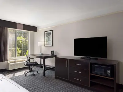 a hotel room with a desk and a flat screen tv at La Quinta by Wyndham Santa Clarita - Valencia in Stevenson Ranch