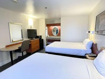 a hotel room with two beds and a desk at Motel 6 Barstow, CA - Lenwood Road in Barstow