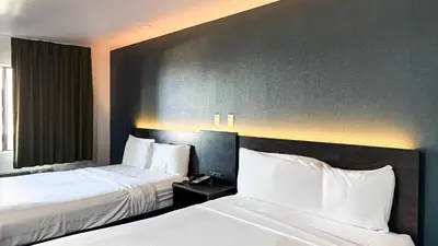 a hotel room with two beds with white sheets at Motel 6 Barstow, CA - Lenwood Road in Barstow