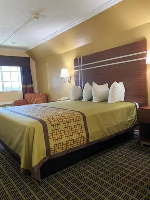 a hotel room with a large bed with white pillows at Americas Best Value Inn - Azusa/Pasadena in Azusa