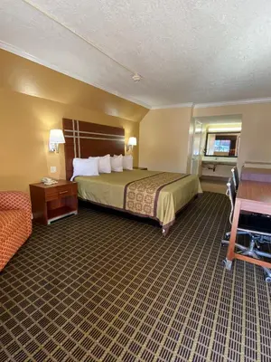 a hotel room with a bed and a couch at Americas Best Value Inn - Azusa/Pasadena in Azusa