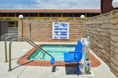 a swimming pool with a blue chair next to a building at Americas Best Value Inn - Azusa/Pasadena in Azusa