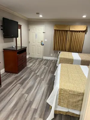 a room with two beds and a flat screen tv at Travelodge by Wyndham Brea in Brea