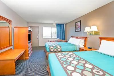 a hotel room with two beds and a television at Super 8 by Wyndham Upland Ontario CA in Upland