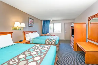a hotel room with two beds and a television at Super 8 by Wyndham Upland Ontario CA in Upland