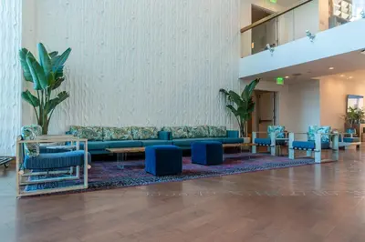a lobby with blue couches and tables and plants at Marina del Rey Hotel in Los Angeles