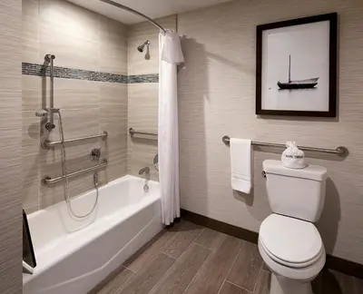 a bathroom with a toilet and a bath tub with a boat on the wall at Marina del Rey Hotel in Los Angeles