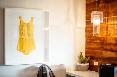a yellow dress hanging on a wall next to a window at Inn at Venice Beach in Los Angeles