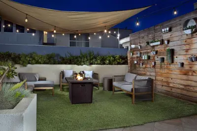 a patio with a table and chairs and a fence at Hilton Garden Inn Los Angeles Marina Del Rey in Los Angeles