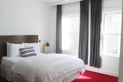 a bedroom with a white bed and two windows at Su Casa at Venice Beach in Los Angeles