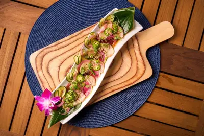a hot dog on a blue plate on a table at Shore Hotel in Los Angeles