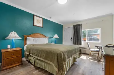 a bedroom with a bed with a green wall at Aristocrat Motel in Baldwin Park