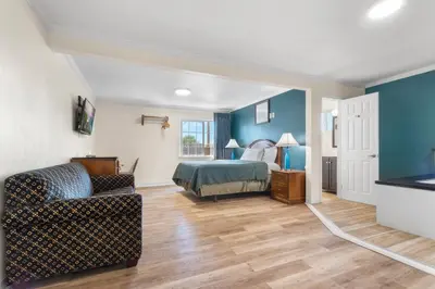 a bedroom with a bed and a living room at Aristocrat Motel in Baldwin Park