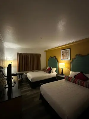 a hotel room with two beds and a desk at Howard Johnson by Wyndham Bakersfield in Bakersfield