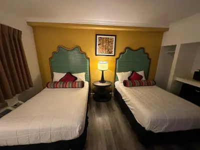 two beds in a hotel room with two bedsskirts at Howard Johnson by Wyndham Bakersfield in Bakersfield