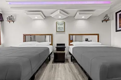 two beds in a room with two mirrors at Rodeway Inn Santa Ana - Garden Grove in Santa Ana