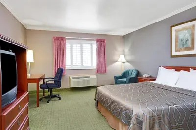 a hotel room with a bed and a flat screen tv at Days Inn by Wyndham West Covina in West Covina