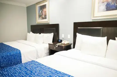 a hotel room with two beds and a phone at Days Inn by Wyndham West Covina in West Covina