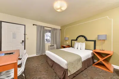 a hotel room with a large bed and a desk and a desk at Americas Best Value Inn Rancho Palos Verdes in Rancho Palos Verdes