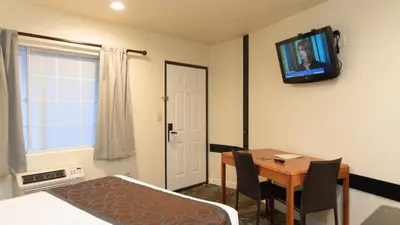 a small room with a table and a television on the wall at Americas Best Value Inn Rancho Palos Verdes in Rancho Palos Verdes