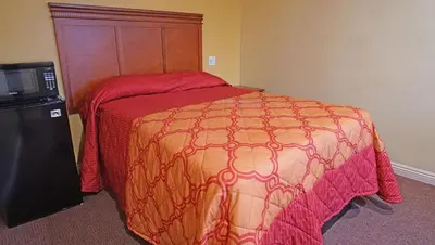 a bedroom with a large bed and a television at Rosa Bell Motel - Los Angeles in Los Angeles