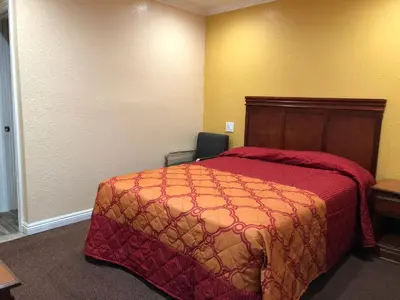 a hotel room with a bed and a chair at Rosa Bell Motel - Los Angeles in Los Angeles