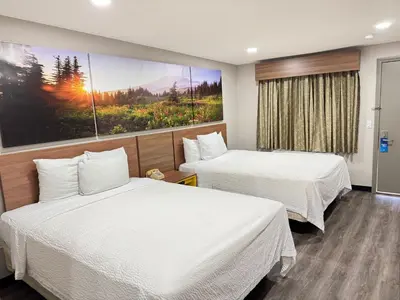 a hotel room with two beds and a painting on the wall at Days Inn by Wyndham Barstow in Barstow