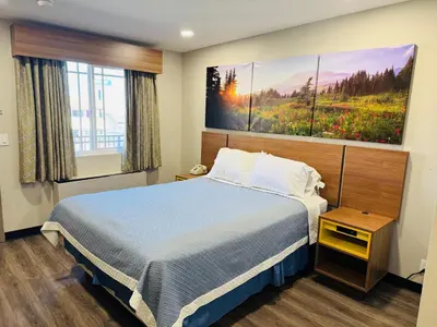a bedroom with a bed and a large painting on the wall at Days Inn by Wyndham Barstow in Barstow