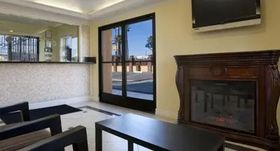 a living room with a fireplace and a tv at Orange Show Inn in San Bernardino